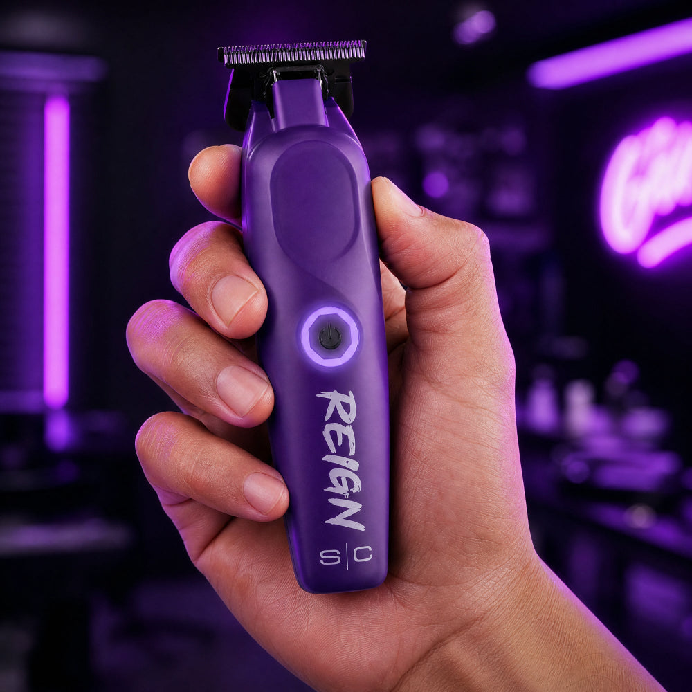 Hand holding a purple grooming tool with 'Reign' branding against a dark background.