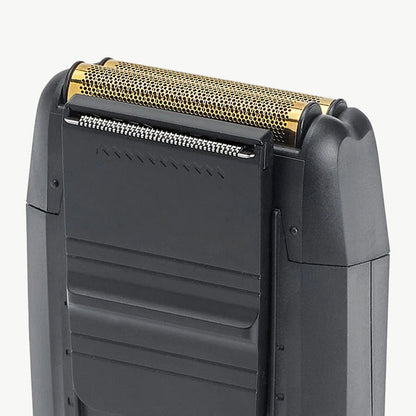Close-up of a black electric shaver showing the top shaving head with a gold-toned mesh filter and silver blade edge, set against a plain light gray background.