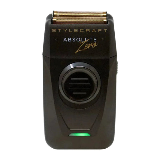 A black Stylecraft Absolute Zero electric shaver with a gold-toned triple-edge blade and a green indicator light, shown against a plain light gray background.