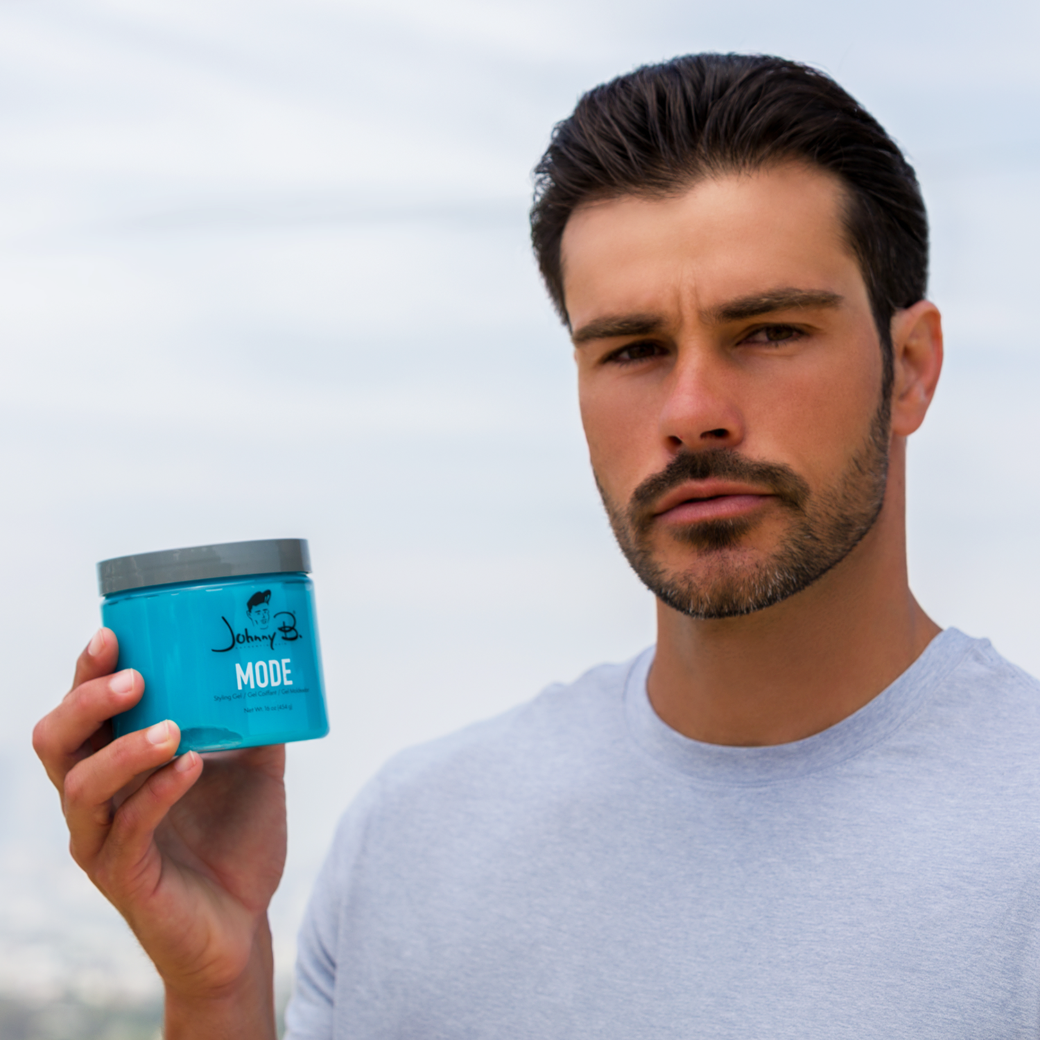 Man holding a blue container labeled 'MODE' against a light background