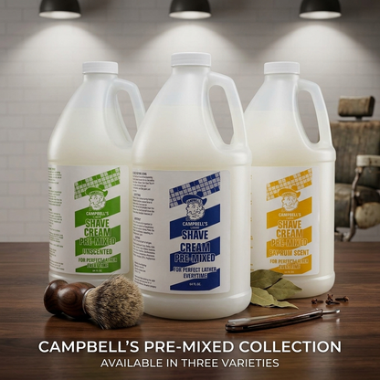 Three large white plastic jugs of Campbell's Pre-Mixed Shave Cream are displayed on a wooden table with grooming accessories, set against a blurred bathroom background with overhead lights. Text at the bottom reads 'CAMPBELL'S PRE-MIXED COLLECTION AVAILAB
