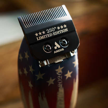 Warm lifestyle closeup of Andis Master 250th Limited Edition clipper blade with bokeh background